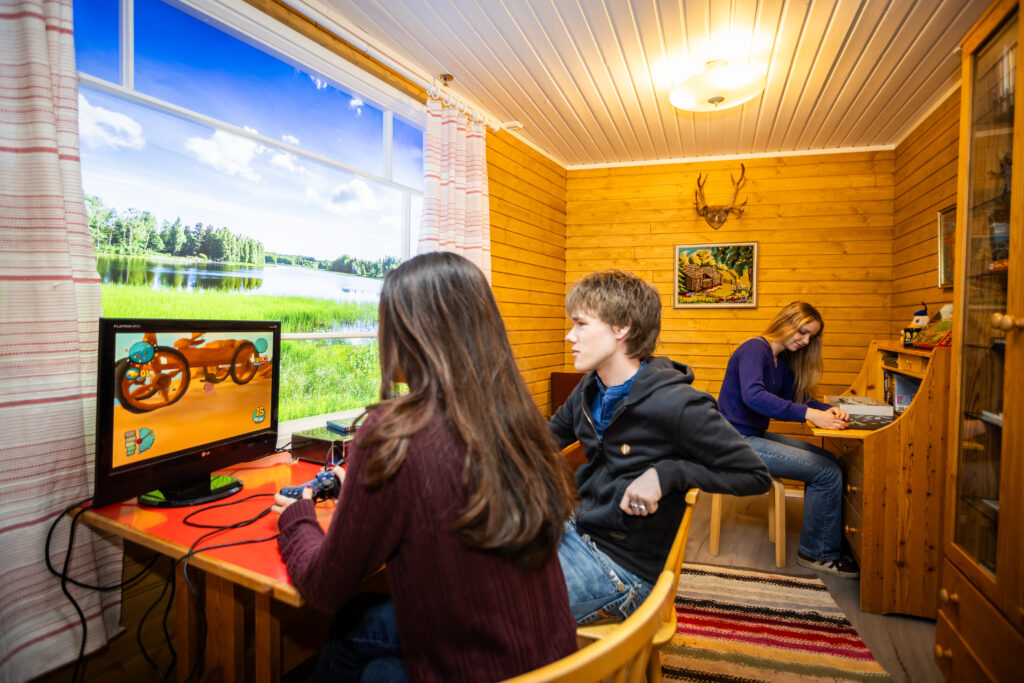 Nuoria pelaamassa mökkihuoneessa Pelimuseossa.