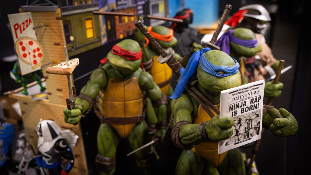 A group of Turtles figures in the display case of the exhibition.
