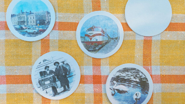 Keltaruutuisella pöytäliinalla pyöreitä siirtokuvia viisi kappaletta.