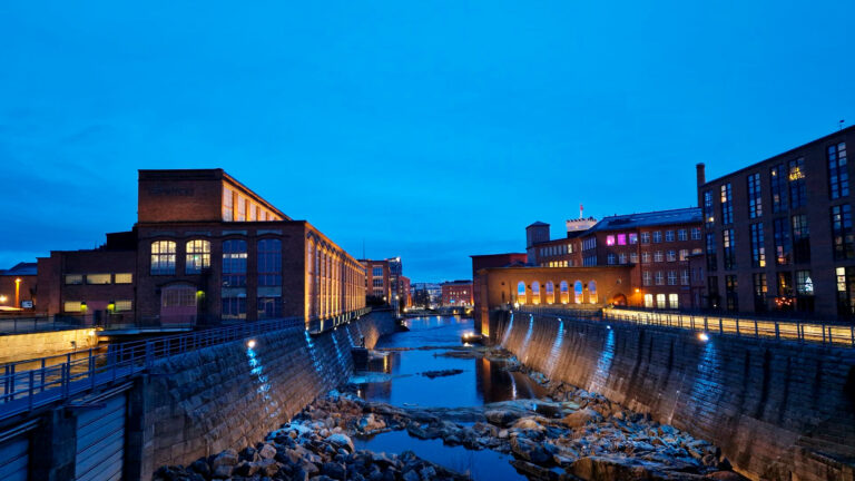 Koskimaisema talvella sinisenä hetkenä, Vapriikin punatiilinen rakennus kuvassa vasemmalla.