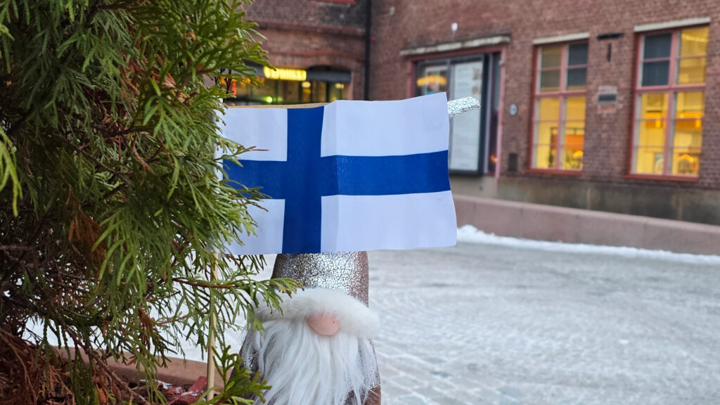 Joulutonttu-koriste pitelee suomenlippua Vapriikin pihalla.
